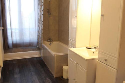 a bathroom with a bath tub and a sink at Hôtel Le 43 in Luxeuil-les-Bains