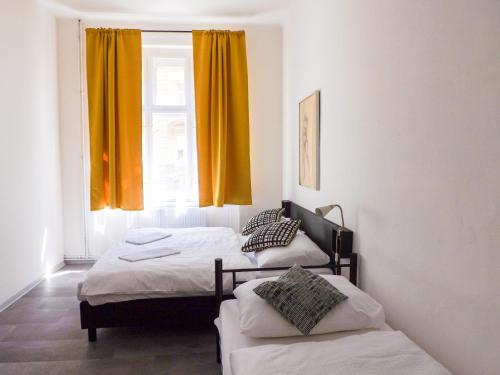 a room with two beds and a window with yellow curtains at Spacious room E1 in centre of Prague in Prague
