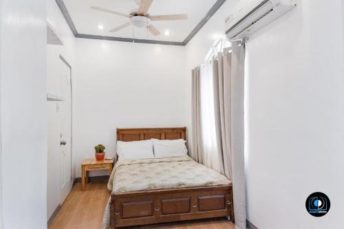 a bedroom with a bed and a ceiling fan at JudyandRobert RentalHouse in Tagbilaran City