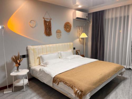 a bedroom with a large bed with white sheets and pillows at 四季餐厅旅馆 in Phumĭ Prêk Chrey
