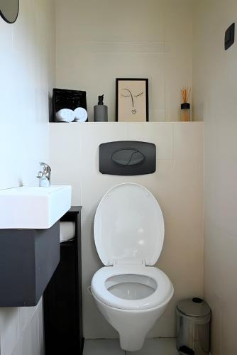 a bathroom with a white toilet and a sink at L Orchidée in Dinant
