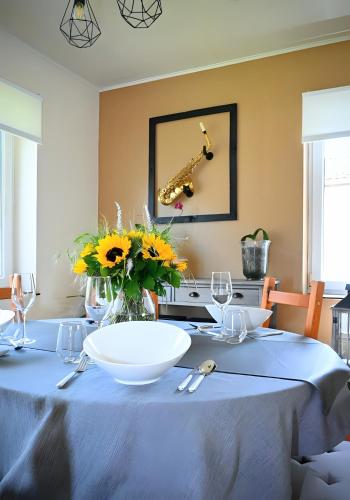 a table with a white bowl and flowers on it at L Orchidée in Dinant