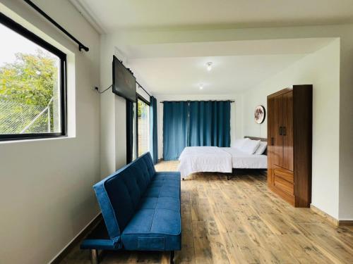 a bedroom with a bed and a couch and a window at Romantic Urban Moment in Baños