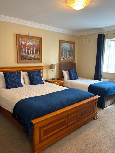 a bedroom with two beds with blue pillows at The Fincourt B&B in Oldcastle