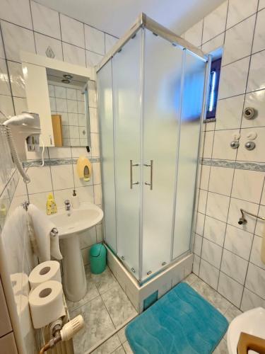 a bathroom with a shower and a toilet and a sink at Rooms Putnik in Senj