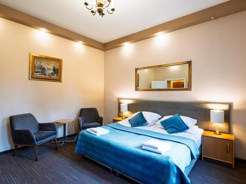 a hotel room with a bed and two chairs at Zamek w Krasiczynie in Krasiczyn