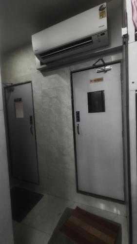 a bathroom with a white door and a window at Ahlan Green Apple Dormitory in Mumbai