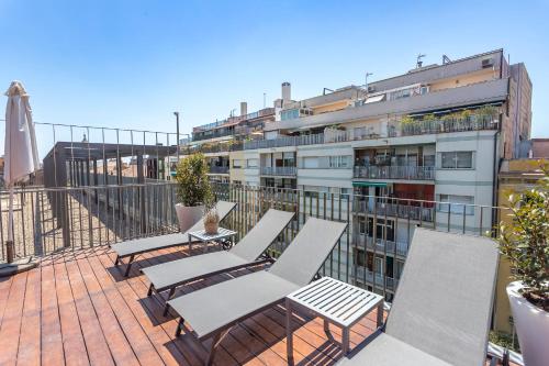 a balcony with white chairs and a building at My Space Emirates - Fully equipped apartments near the Beach with shared pool in Barcelona
