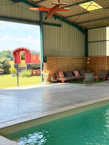 un pavillon avec une piscine et une maison dans l'établissement La roulotte Champêtre des Grillots, à Beaulon