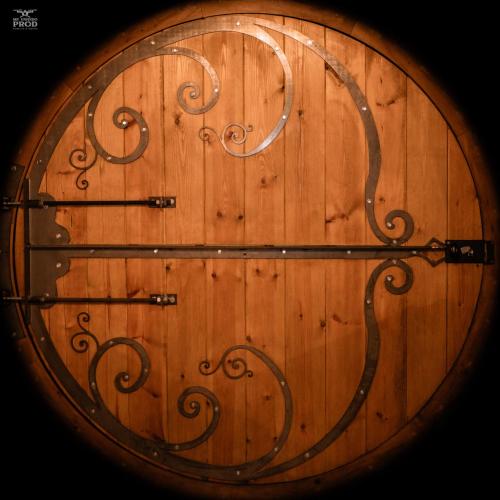 zbliżenie drewnianych drzwi z metalową klamką w obiekcie maison de hobbit 