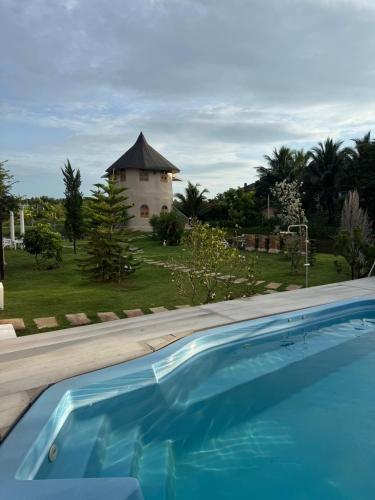a swimming pool with a building in the background at Pundin Khaoyai in Nong Sarai