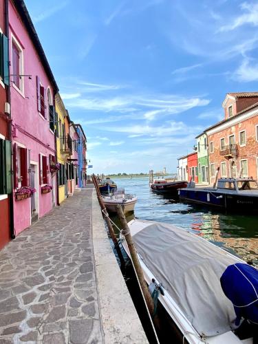a canal with colorful buildings and a boat on the water at Casa Cabini Piave in Eraclea