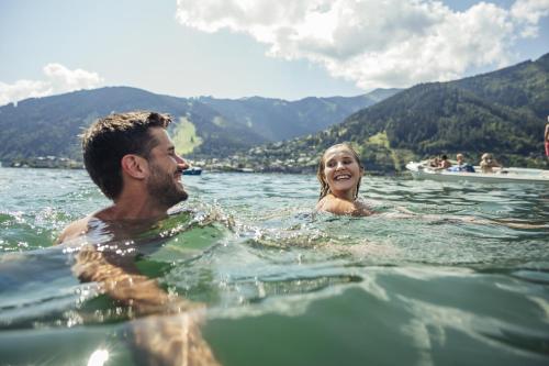 a man and a woman swimming in the water at AlpenParks Chalet & Apartment Steve Lodge Viehhofen in Viehhofen