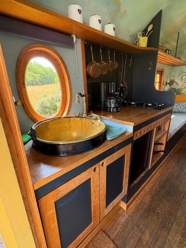 La salle de bains est pourvue d'un comptoir en bois et d'un lavabo. dans l'établissement La roulotte Champêtre des Grillots, à Beaulon