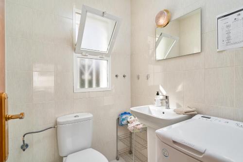 Un baño blanco con inodoro y lavabo. en Casa Alina, en Nerja