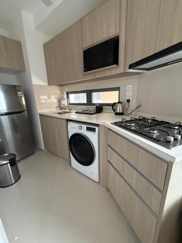 a kitchen with a stove and a washing machine at Colombo, Trizen Luxury Apartments, Sri Lanka in Colombo