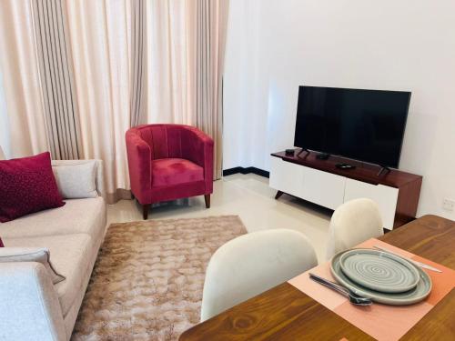a living room with a couch and a tv at Colombo, Trizen Luxury Apartments, Sri Lanka in Colombo
