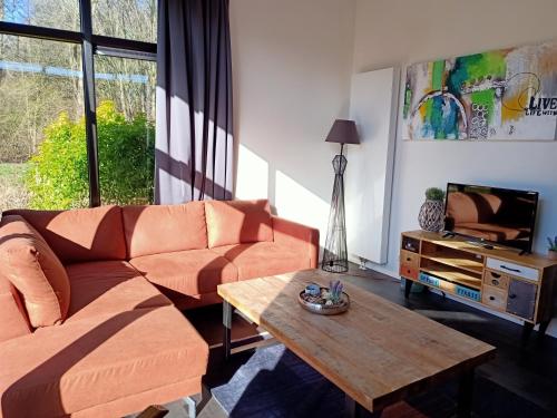 a living room with a couch and a coffee table at Holiday home - area AMSTERDAM - 6 people in Halfweg