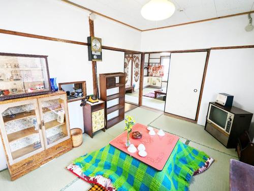 a living room with a table and a tv at retro48Nagasakiかすてら in Nagasaki