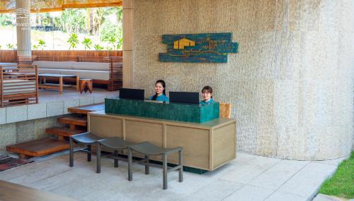 two people sitting at a counter with their laptops at Harvest Day Hoi An in Hoi An