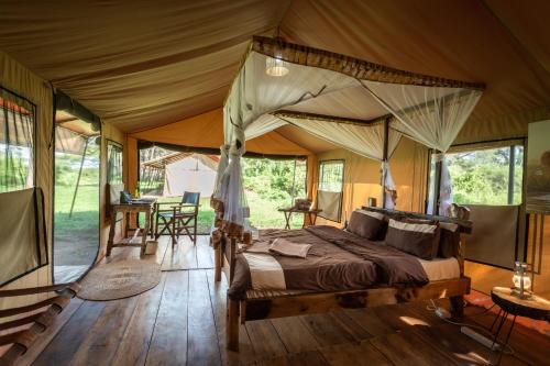 a bedroom with a bed in a tent at Baobab Tented Camp in Kwa Kuchinia