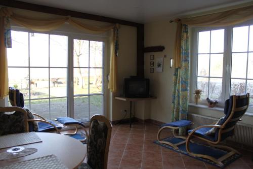 a dining room with a table and chairs and windows at Ferienhaus Am See In Blankensee Groß Schönfeld in Blankensee