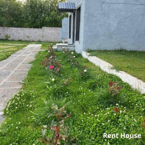 a garden with flowers in the grass next to a house at Armenia RENT HOUSE Byurakan in Byurakan