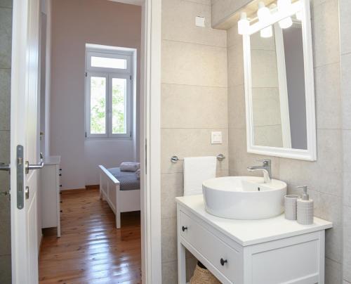 a white bathroom with a sink and a mirror at Andros Neoclassical Villa NP1926 with Private Pool in Steniaí