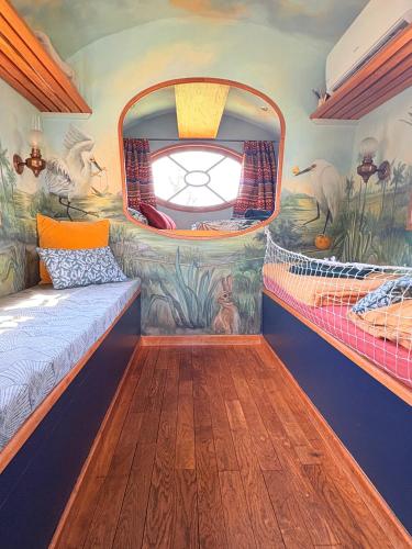 Cette chambre comprend un lit et une fresque murale. dans l'établissement La roulotte Champêtre des Grillots, à Beaulon