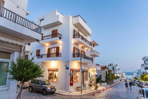 a white building on the side of a street at eleni luxury apartment in Tinos Town