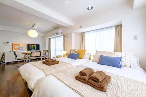 two beds in a bedroom with towels on them at Palaisgrace Shibuya - Live Like a Trendy Local in Sangenjaya 三軒茶屋 - Direct Shibuya Access in Tokyo