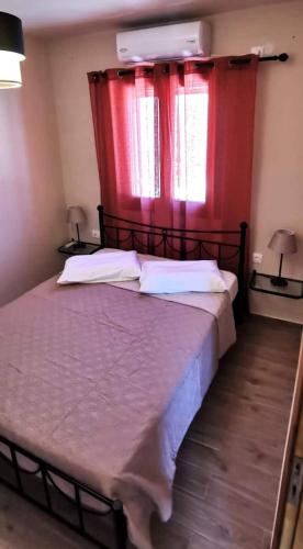 a bedroom with a large bed with red curtains at Dimitras house palaiopoli in Kythira