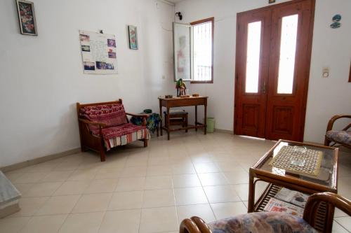 a living room with chairs and a table and a door at Stratis Studios in Anaxos