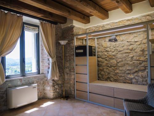 a living room with a stone wall and windows at Tenuta Colfiorito in Castel Madama
