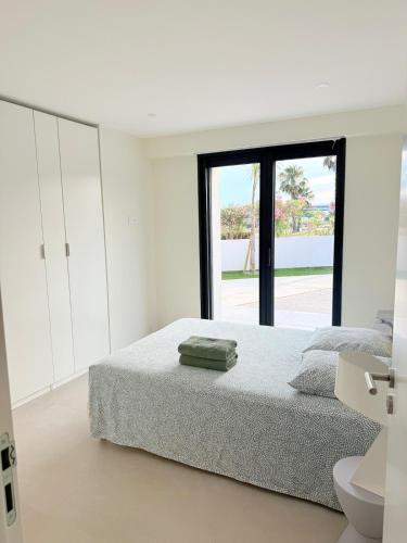 une chambre blanche avec un lit et une fenêtre dans l'établissement Villa de rêve avec piscine privée, entièrement rénové, au Barcarès