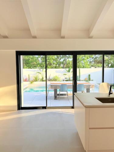 une cuisine ouverte et une salle à manger avec des portes coulissantes en verre dans l'établissement Villa de rêve avec piscine privée, entièrement rénové, au Barcarès