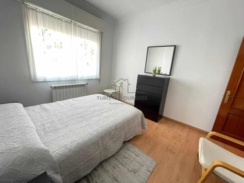 sypialnia z łóżkiem, komodą i oknem w obiekcie O cuarto de abastos w mieście Ourense