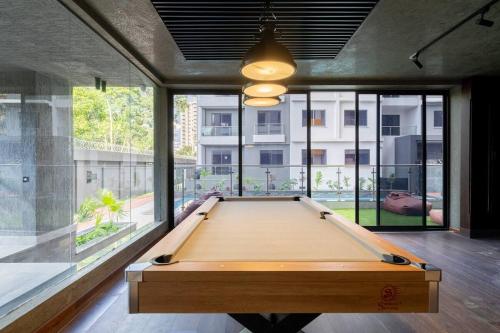 a large wooden pool table in a room with windows at Staylah Sanctuary 1br in Wilma Tower Apartment- Kilimani in Nairobi