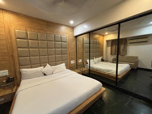 Un dormitorio con dos camas y un sofá. en Hotel Sahar Garden Near Mumbai International Airport, en Bombay