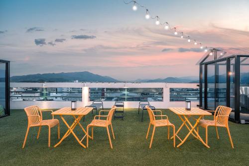 a patio with tables and chairs on a roof at Hotel Palace Gyeongju in Gyeongju