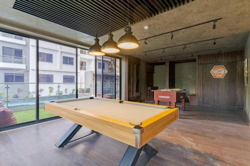 a pool table in the middle of a room with windows at Staylah Sanctuary 1br in Wilma Tower Apartment- Kilimani in Nairobi