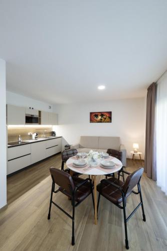 a kitchen and living room with a table and chairs at Villa Betty Apartments in Arco