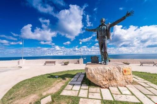a statue of a man standing on top of a rock at Hotel San Giovanni in Polignano a Mare