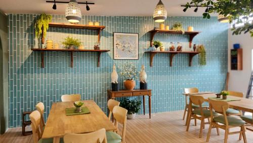 a dining room with tables and chairs and blue tiles at Suan Pa Khao Lom Homestay 
