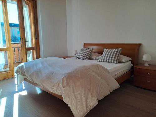 a bedroom with a large bed with pillows on it at Appartamento Maurizio in Spormaggiore