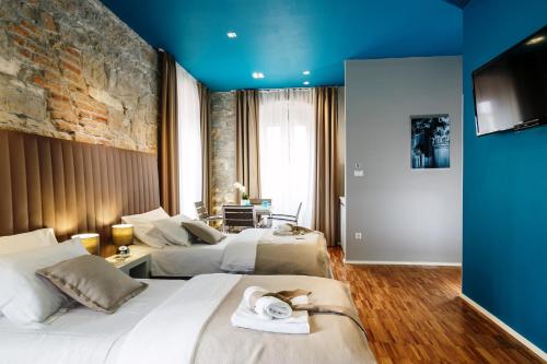 斯普利特的住宿－里瓦豪華客房酒店，酒店客房设有两张床和蓝色的墙壁。