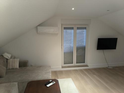 a living room with a couch and a flat screen tv at Ferienwohnung für 2-3 Personen in Sinzheim