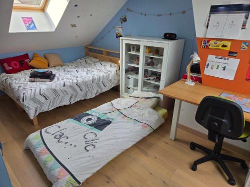 a bedroom with two beds and a desk and a chair at 2 Chambres pour évènement circuit Bugatti in Mulsanne