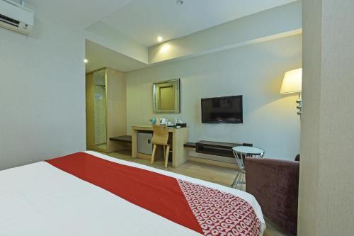 a hotel room with a bed and a desk at Collection O Melaka Near Dataran Pahlawan Formerly Ideals Hotel in Melaka