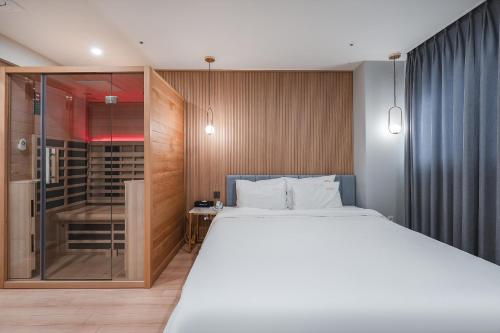 a bedroom with a bed and a walk in shower at Hotel Palace Gyeongju in Gyeongju
